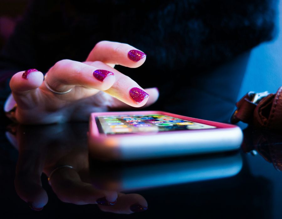 Woman's hand choosing app on cell phone