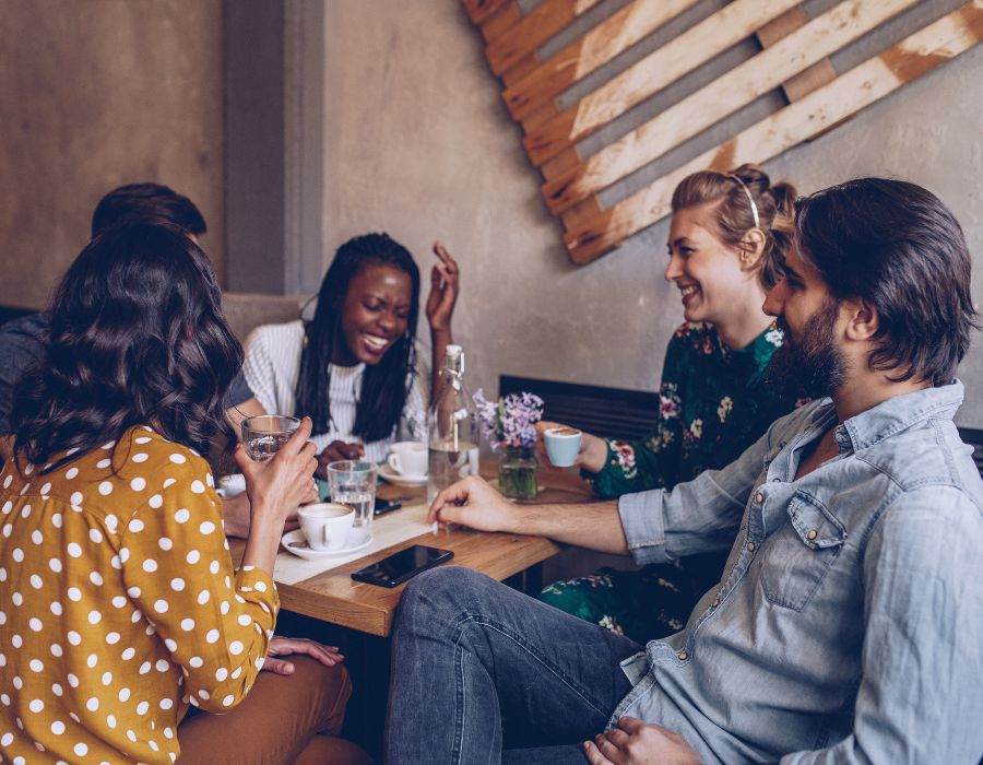 Group at a coffee shop smiling and laughing together