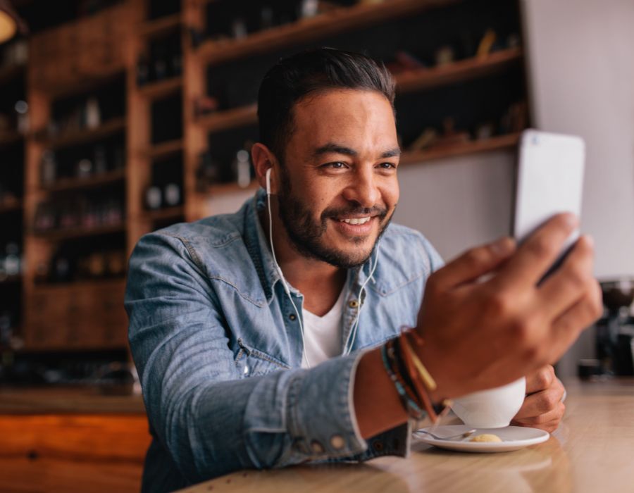 Smiling man having coffee while on video call