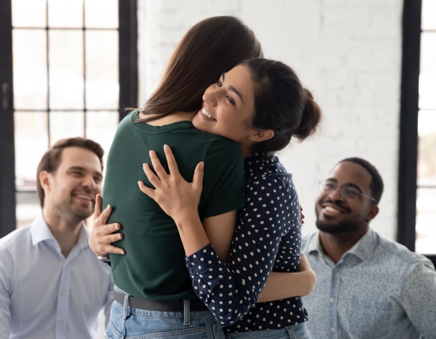 Two women smiling and hugging