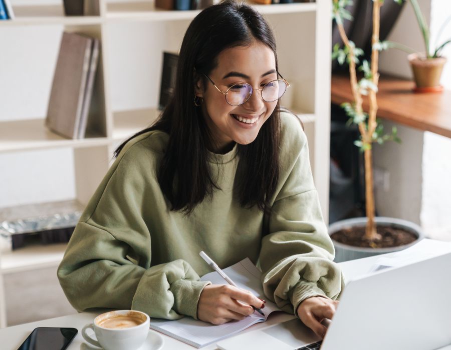 Girl smiling and working at laptop