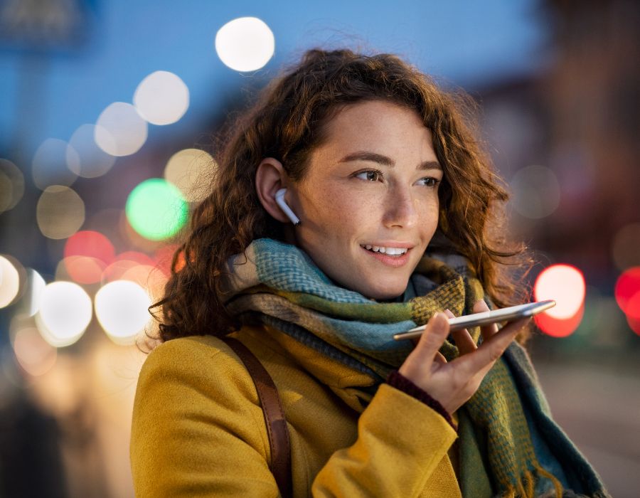 Smiling woman talking on phone while walking downtown