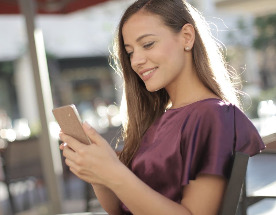 Woman smiling while looking at phone